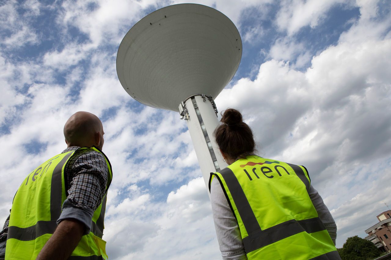 due dipendenti iren guardano una torre dell'acqua